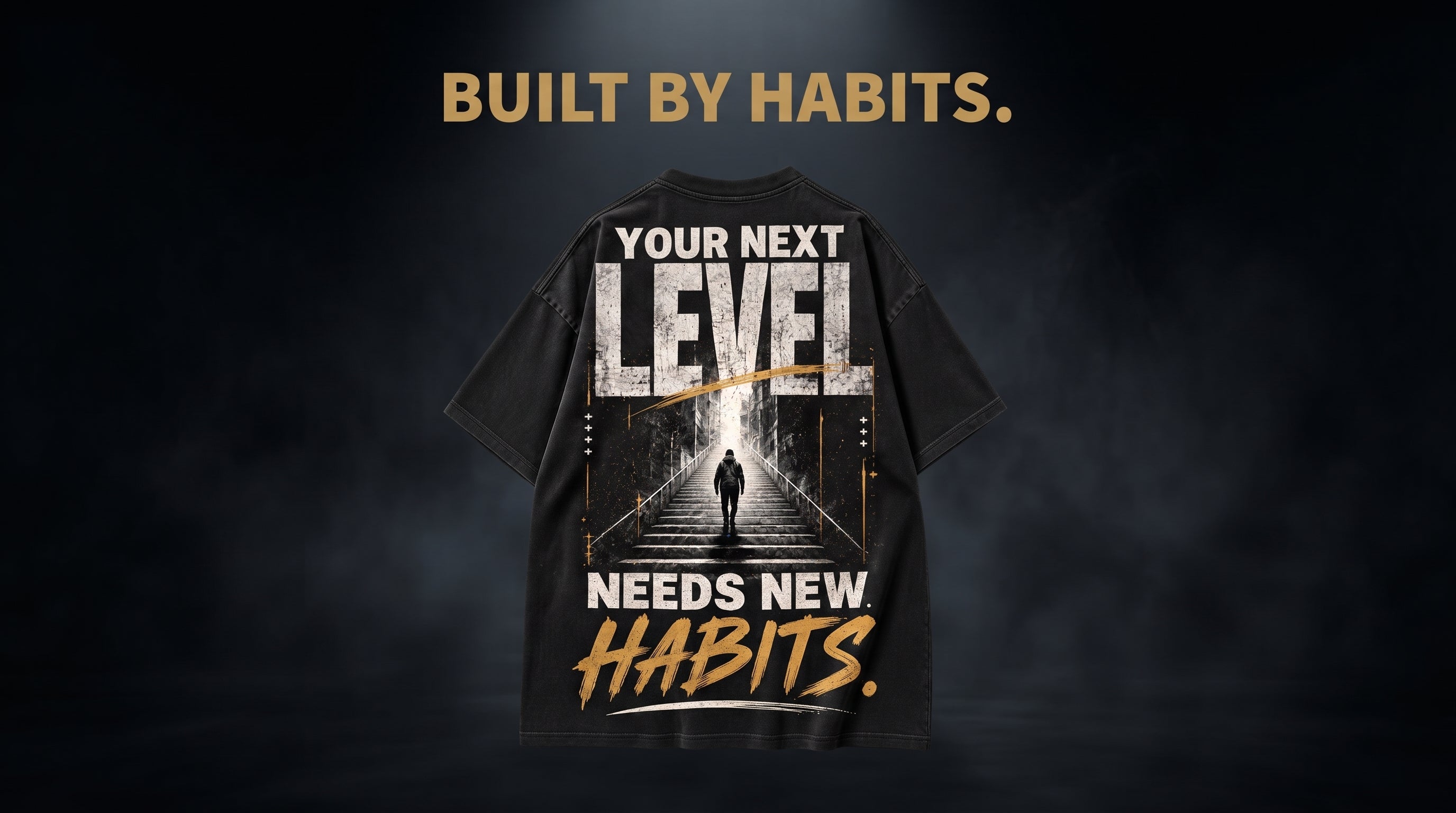 Back of black t-shirt featuring large 'Your Next Level Needs New Habits' typographic design with staircase illustration